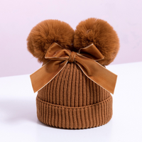 Knitted pompom hat with velvet bow
